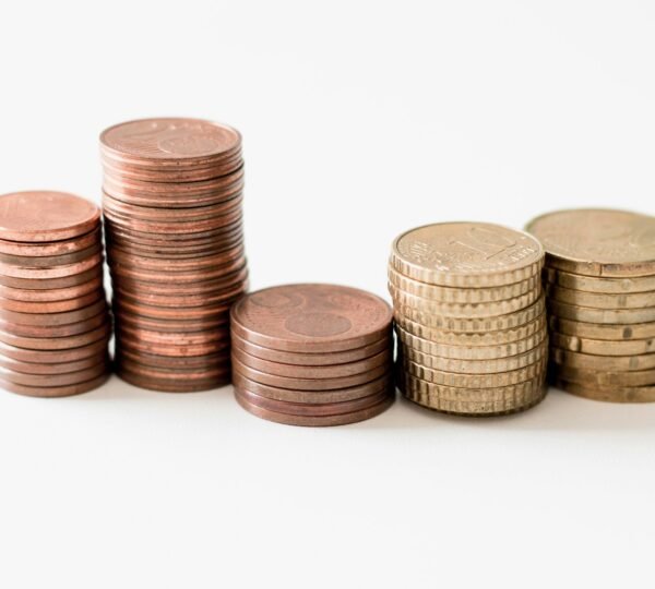 stacked round gold-colored coins on white surface